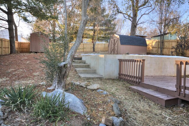 view of yard featuring a storage shed and a wooden deck