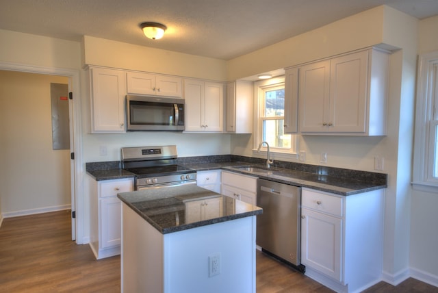 kitchen featuring white cabinetry, sink, stainless steel appliances, and a center island