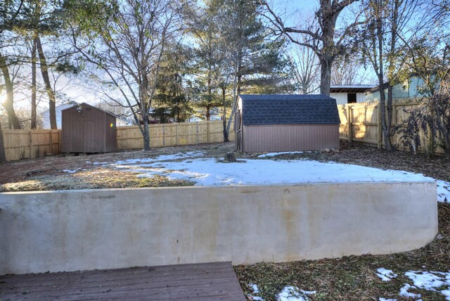 yard layered in snow featuring a shed