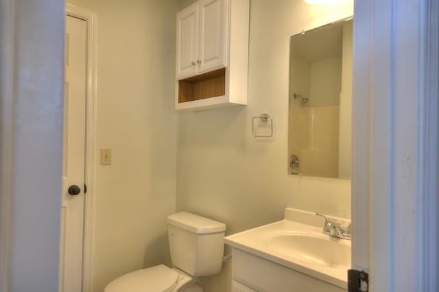 bathroom featuring walk in shower, vanity, and toilet