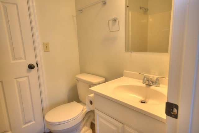 bathroom featuring walk in shower, vanity, and toilet