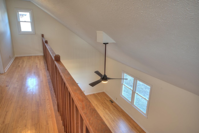 staircase featuring hardwood / wood-style flooring, vaulted ceiling, and a textured ceiling