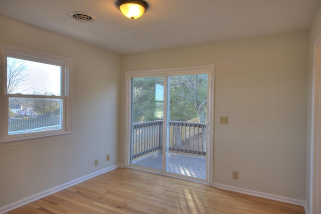 empty room with plenty of natural light and light wood-type flooring