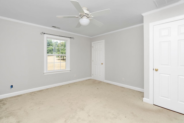 empty room with crown molding, light colored carpet, and ceiling fan