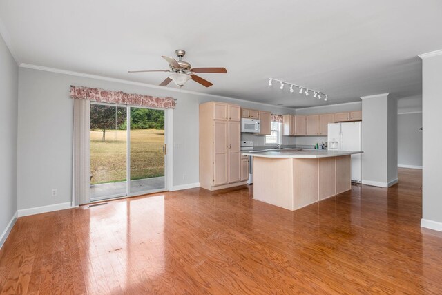 kitchen featuring hardwood / wood-style floors, white appliances, a center island, and light brown cabinets