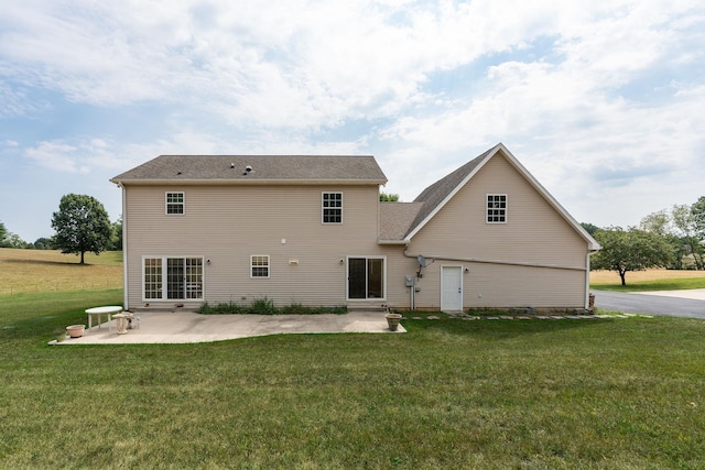 back of house with a lawn and a patio area