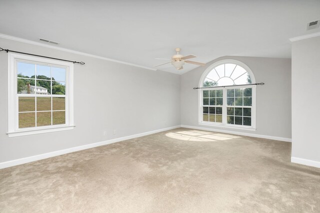 carpeted empty room with ceiling fan, ornamental molding, vaulted ceiling, and plenty of natural light