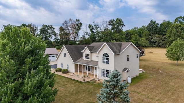 rear view of house with a yard and a patio