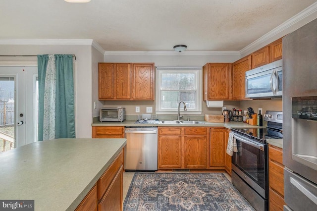 kitchen with ornamental molding, appliances with stainless steel finishes, and sink