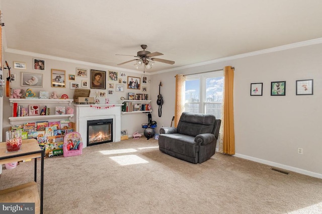 living area featuring crown molding, ceiling fan, and carpet floors