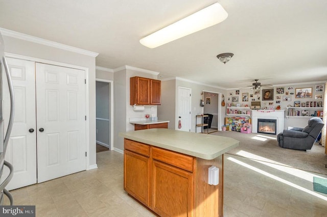 kitchen featuring crown molding, a kitchen island, and ceiling fan