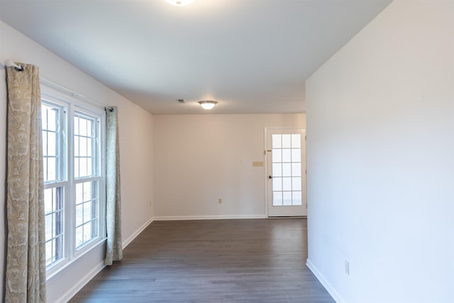 unfurnished room featuring dark wood-style flooring and baseboards