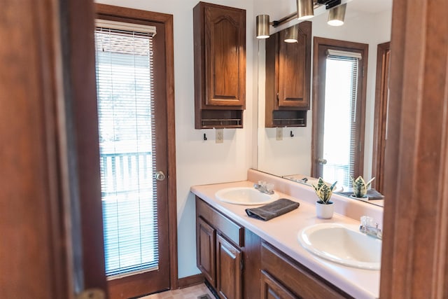 full bath with plenty of natural light, a sink, and double vanity