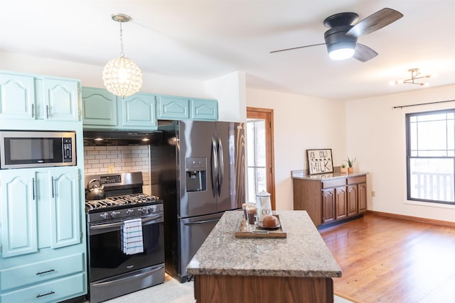 kitchen with pendant lighting, stainless steel appliances, decorative backsplash, ventilation hood, and wood finished floors