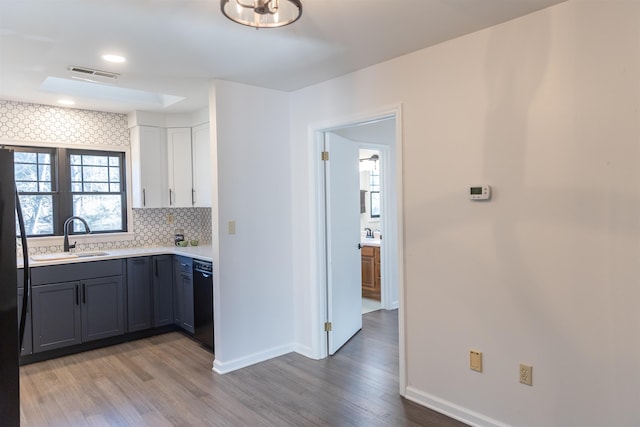 kitchen featuring a sink, visible vents, white cabinetry, light countertops, and gray cabinets