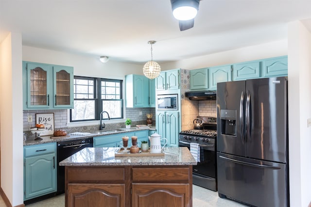 kitchen featuring a kitchen island, decorative light fixtures, stainless steel appliances, under cabinet range hood, and a sink