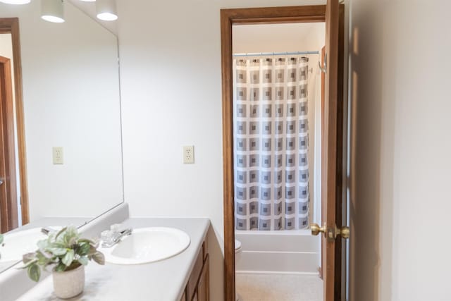 bathroom featuring toilet, shower / bath combo with shower curtain, and vanity