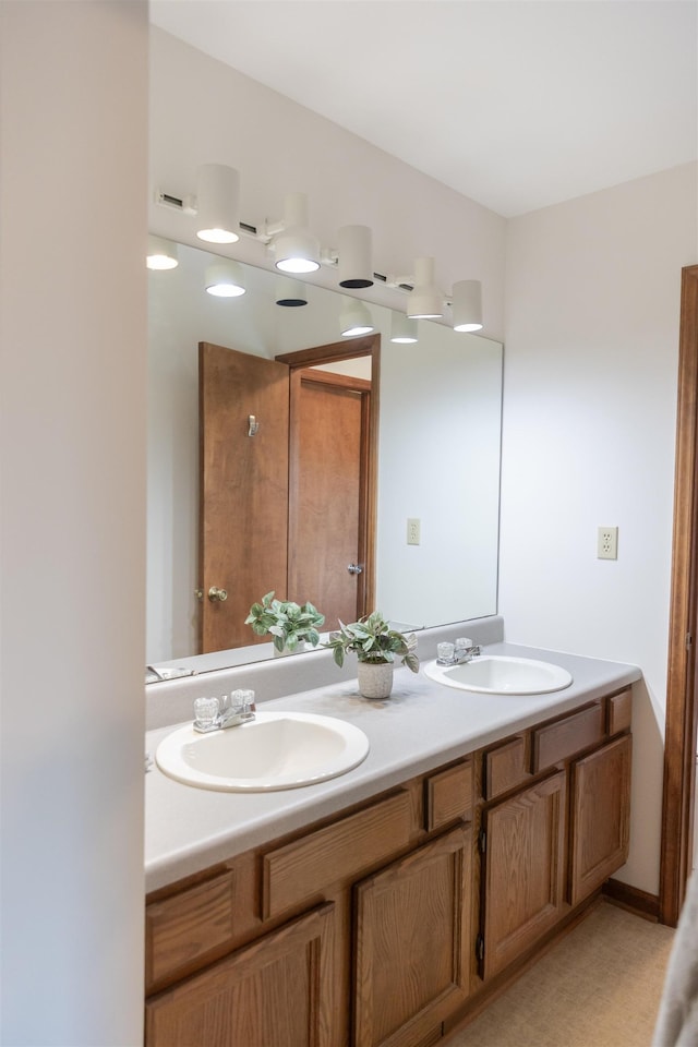 bathroom featuring a sink and double vanity