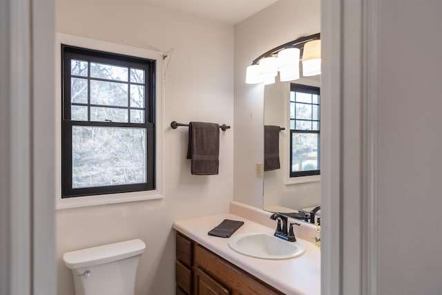 half bathroom with vanity and toilet