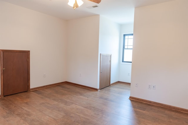 unfurnished room with light wood-type flooring, visible vents, and baseboards