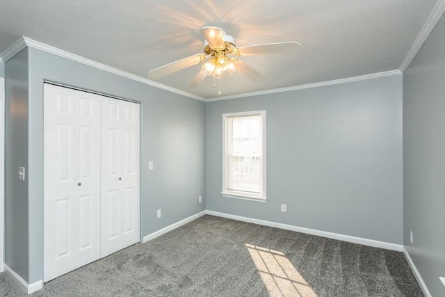 unfurnished bedroom featuring ceiling fan, a closet, ornamental molding, and carpet