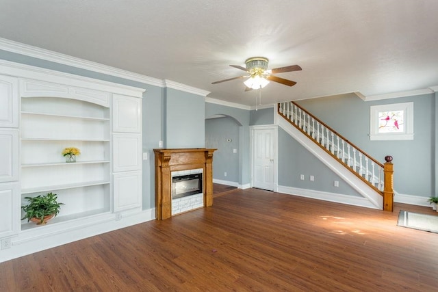 unfurnished living room featuring crown molding, built in features, dark hardwood / wood-style floors, and ceiling fan