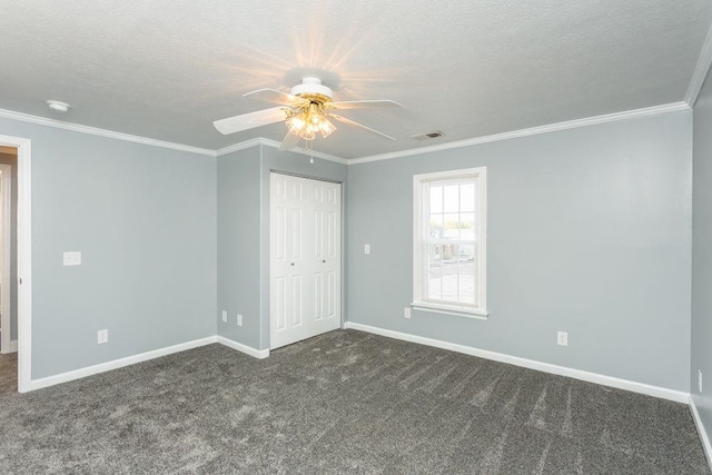 carpeted empty room featuring crown molding, ceiling fan, and a textured ceiling