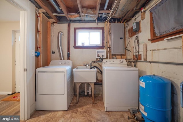 clothes washing area featuring laundry area, electric panel, a sink, and separate washer and dryer