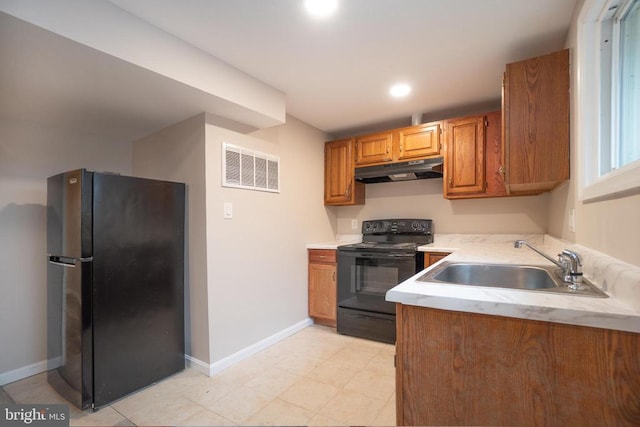 kitchen with under cabinet range hood, visible vents, light countertops, brown cabinets, and black appliances