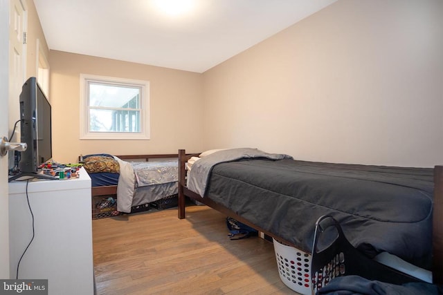 bedroom featuring lofted ceiling and light wood-type flooring