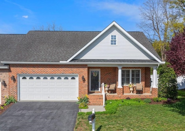 traditional-style house featuring a porch, driveway, a front yard, a garage, and brick siding