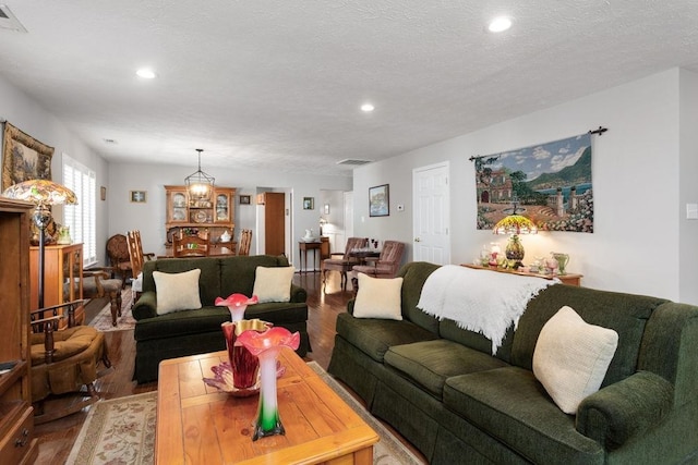 living area with recessed lighting, a chandelier, visible vents, and wood finished floors
