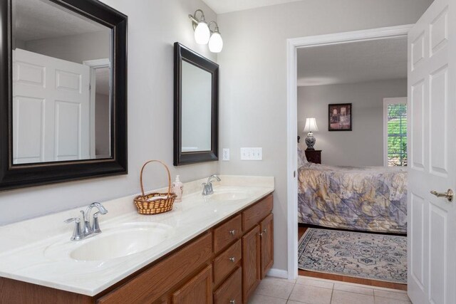 bathroom featuring a sink, tile patterned floors, double vanity, and connected bathroom