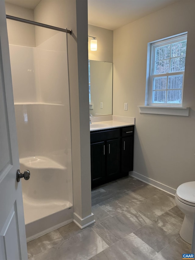 bathroom with vanity, a shower, and toilet