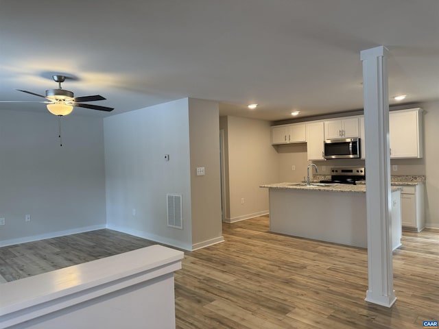 kitchen with white cabinetry, light stone countertops, light hardwood / wood-style flooring, and stainless steel appliances