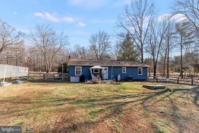 view of front of house featuring a front yard, cooling unit, and fence