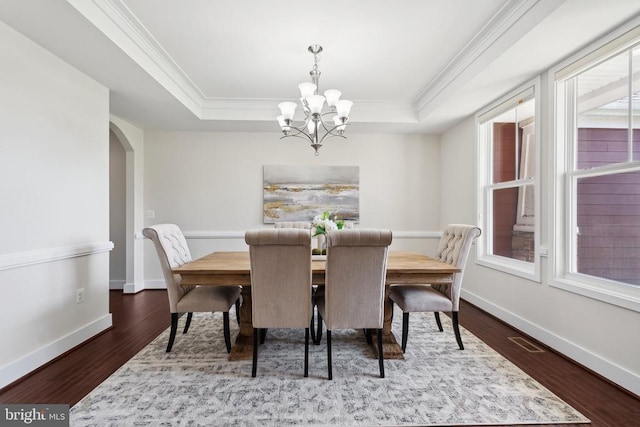 dining area featuring ornamental molding, a tray ceiling, and wood finished floors