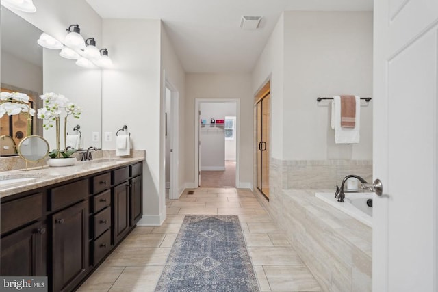 bathroom with a sink, visible vents, a shower stall, a bath, and a walk in closet