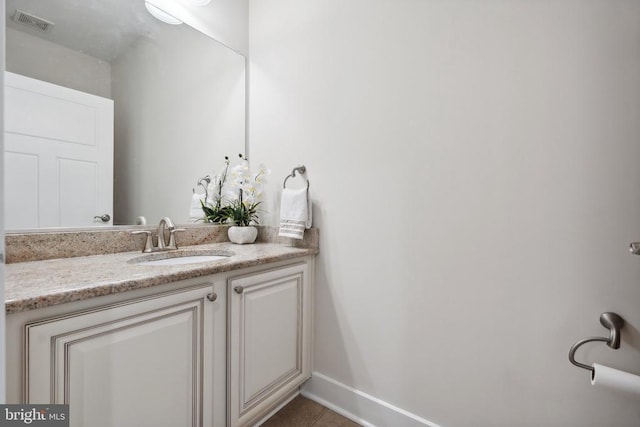 bathroom with tile patterned flooring, visible vents, baseboards, and vanity