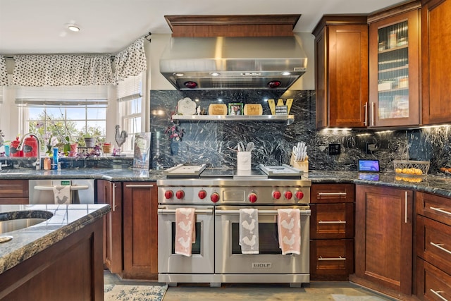 kitchen with dark stone counters, decorative backsplash, wall chimney range hood, and stainless steel appliances