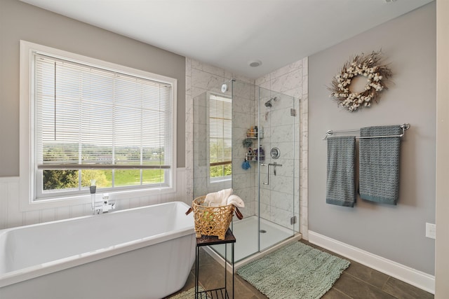 bathroom with a freestanding tub, tile patterned flooring, and a stall shower