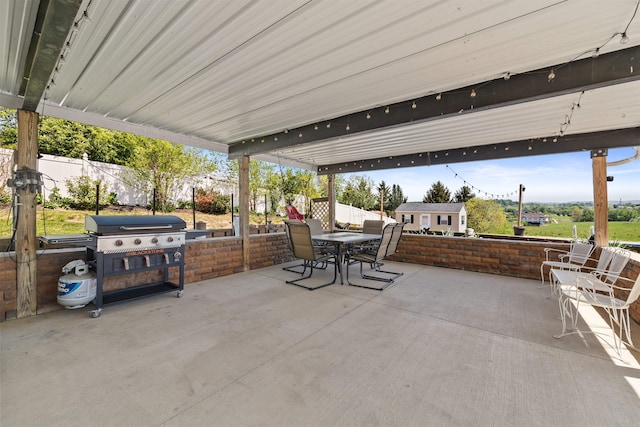 view of patio featuring fence, outdoor dining area, and a grill
