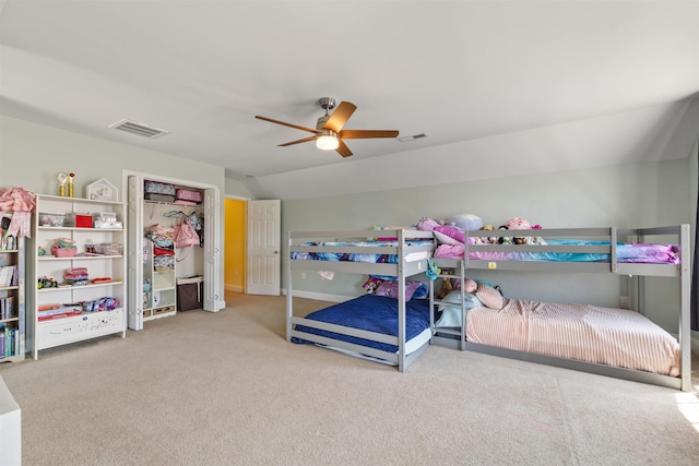 bedroom with carpet flooring, a ceiling fan, visible vents, and vaulted ceiling