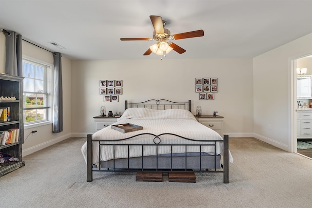 carpeted bedroom featuring baseboards, visible vents, ceiling fan, and ensuite bathroom