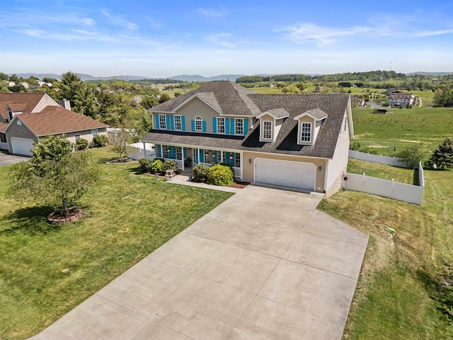 view of front facade featuring a garage, a front lawn, fence, covered porch, and driveway