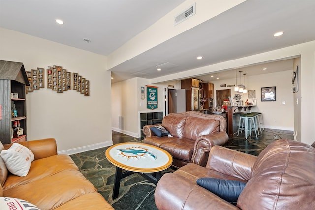living area featuring recessed lighting, baseboards, and visible vents
