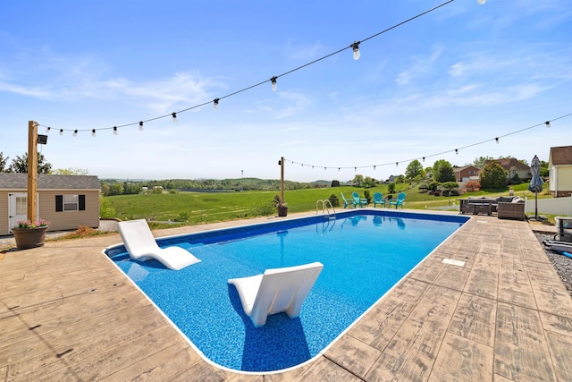 outdoor pool with a patio, an outdoor living space, and an outbuilding