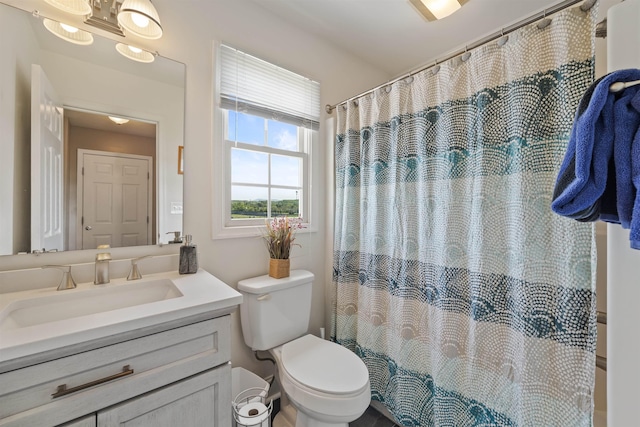 bathroom featuring vanity, curtained shower, and toilet