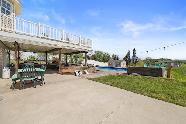 view of patio / terrace with a deck, outdoor dining space, and an outdoor pool