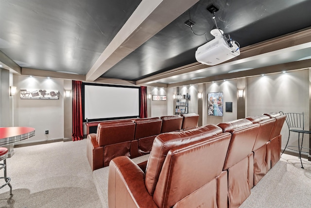 carpeted home theater room featuring baseboards and beam ceiling